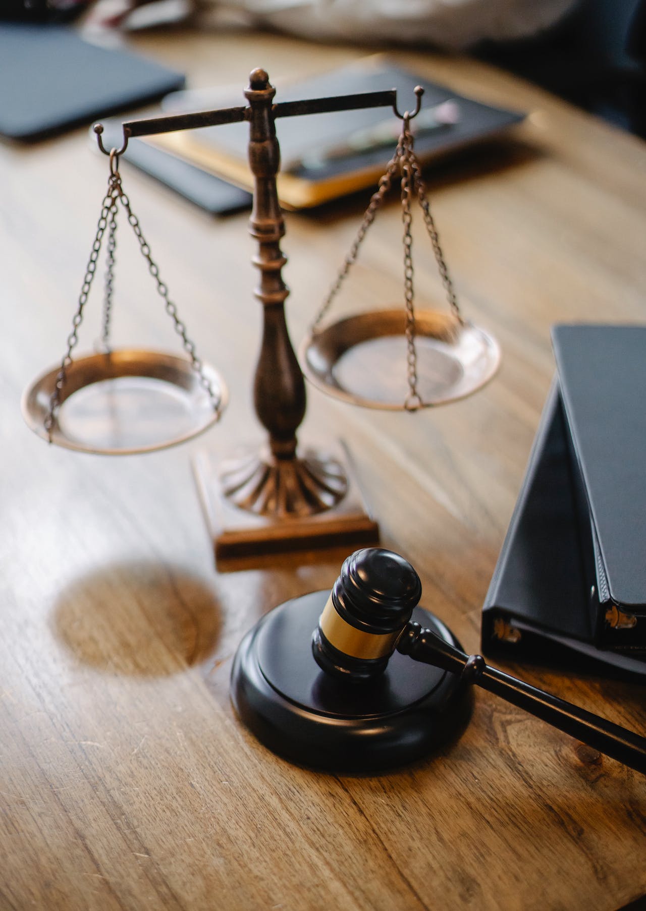 a judge's gavel next to the scales of justice on a wooden desk